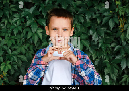 Happy boy making a heart shape with his hands Stock Photo