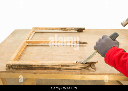 Restoration of a window frame. Carpenter using a chisel while repairing an old window sash. Sash window restoration. Stock Photo