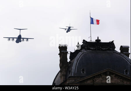 Paris, France. 14th July, 2019. French military aircrafts fly over the Pyramid of Louvre Museum during the annual Bastille Day military parade in Paris, France, on July 14, 2019. Credit: Gao Jing/Xinhua/Alamy Live News Stock Photo