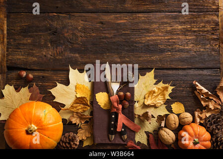 Thanksgiving Table Setting, top view, banner. Autumnal holiday decorated table with pumpkins, cutlery, yellow leaves. Stock Photo