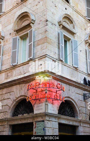 Ascoli Piceno, Italy - June 27, 2019: glowing neon sign in the old town readings: 'Doctor Rosati Central pharmacy' at sunset Stock Photo