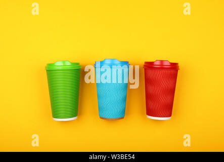 https://l450v.alamy.com/450v/w3be54/close-up-three-crimped-disposable-paper-takeaway-coffee-cups-red-green-and-blue-with-plastic-cap-over-vivid-yellow-background-flat-lay-elevated-t-w3be54.jpg