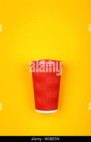 Close up one crimped disposable red paper takeaway coffee cup over vivid yellow background, flat lay, elevated top view, directly above Stock Photo