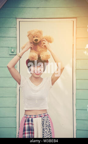 Portrait of happy female with a lovely teddy bear looking at camera. Stock Photo