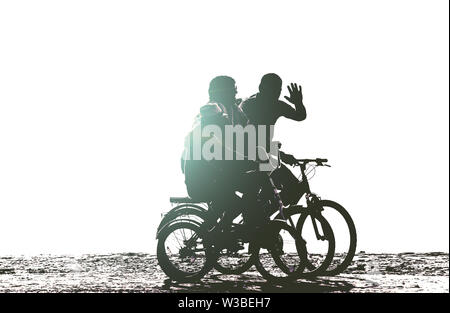 positive family rides bicycles on beach Stock Photo