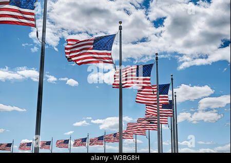 A circle of American flags circle the Washington Monumument on the National Mall in Washington DC. Stock Photo