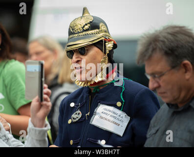 Berlin, Germany. 14th July, 2019. A man in a historical uniform takes part in a demonstration against a right-wing extremist rally on Breitscheidplatz. On his lapel hangs a note with the inscription: 'Sergeant A.D. Adolf Hoeltler - Doitschleerer'. Credit: Paul Zinken/dpa/Alamy Live News Stock Photo