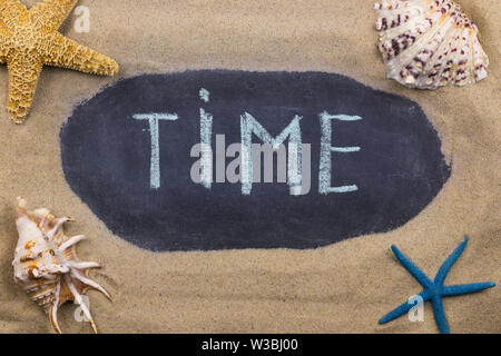 Handwritten chalk inscription TIME on blackboard, lying among the seashells and starfish on the sand. Top view Stock Photo