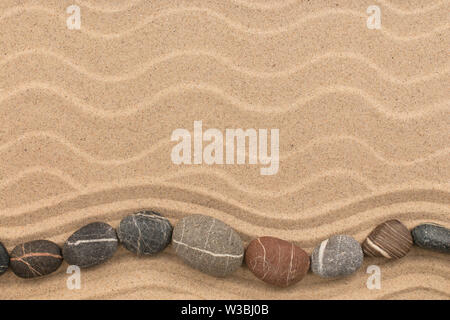 Stones in the form of a zigzag lies on the dunes. With space for design, text place. Top view Stock Photo
