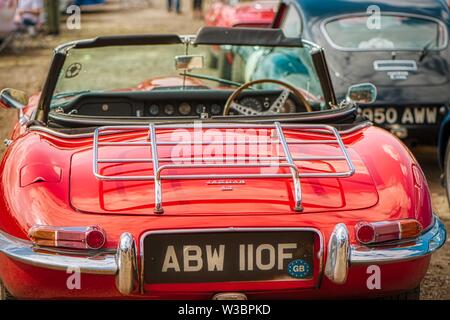 Red E Type Jaguar in a black studio from a low front 3 4 ...