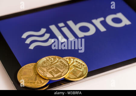 Golden coins on top of tablet computer for Libra cybercurrency Stock Photo