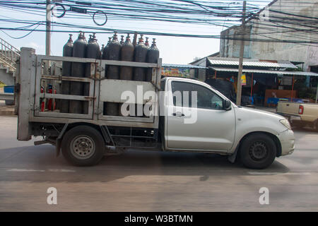 Pickup carries a welding bottles. Car transports gas containers on street city. Stock Photo