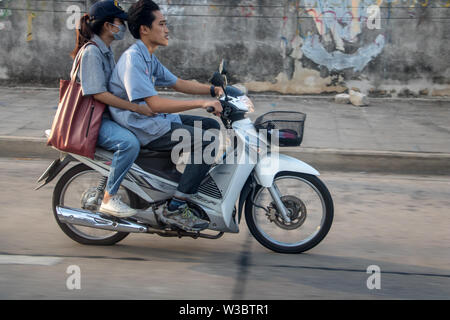 SAMUT PRAKAN, THAILAND, APR 27 2019, Man with woman riding a motorcycle. Couple rides motorcycle in the city streets. Stock Photo