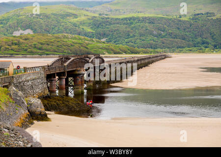 The historic railway bridge across the Mawddach estuary viewed from the harbour in Barmouth, Gwynedd, Wales, UK Stock Photo