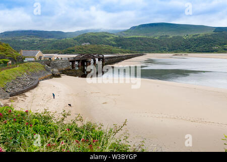 The historic railway bridge across the Mawddach estuary viewed from the harbour in Barmouth, Gwynedd, Wales, UK Stock Photo