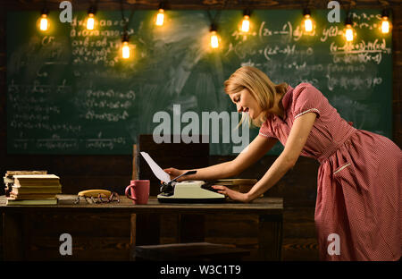 Profile of a young woman typing with a typewriter in school Stock Photo