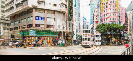 Wan Chai, Hong Kong - Jul 4, 2019: Panoramic view of crowded people and car traffic transport across intersection on Johnston road in Wan Chai distric Stock Photo
