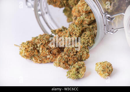Detail of cannabis buds on clear glass jar isolated on white - medical marijuana dispensary concept Stock Photo