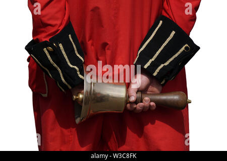 Rear view of a town crier in England, dressed in traditional red coat and holding his bell behind is back Stock Photo