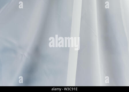 flying transparent fabric. white fabric with waves on it. curtain folds. Stock Photo
