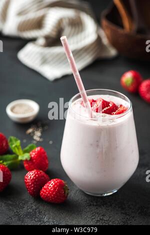 Strawberry milkshake or smoothie in glass on black backgroud. Healthy vegan vegetarian food Stock Photo