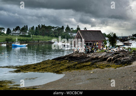 Historic Bailey Fish House covered in lobster buoys along Mackerel Cove on Bailey Island on a stormy summers day in Harpswell, Maine. Stock Photo