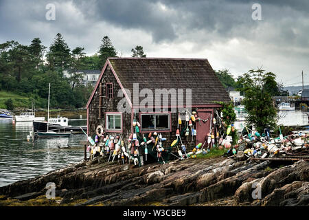 Historic Bailey Fish House covered in lobster buoys along Mackerel Cove on Bailey Island on a stormy summers day in Harpswell, Maine. Stock Photo