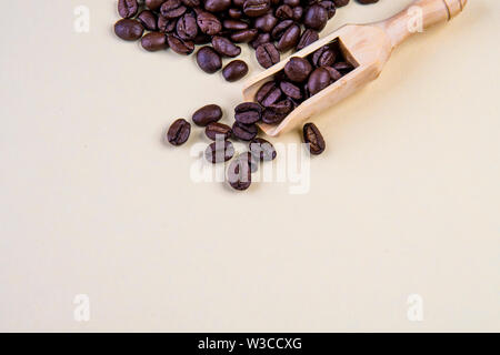 Coffee beans on beige background with wooden spoon Stock Photo