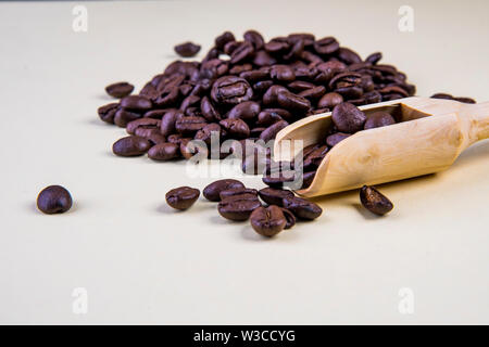 Coffee beans on beige background with wooden spoon Stock Photo