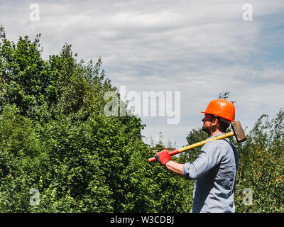 Man holding a hammer in the park Stock Photo