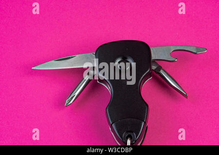 Tools with knife and opener and much more on pink Stock Photo