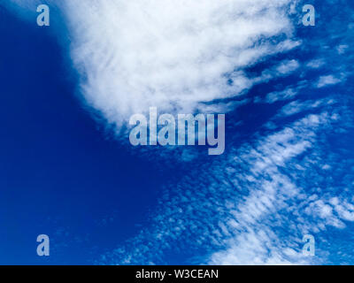 Cirrocumulus clouds are small rounded puffs that usually appear in long rows high in the sky. Cirrocumulus are usually white, but sometimes appear gra Stock Photo