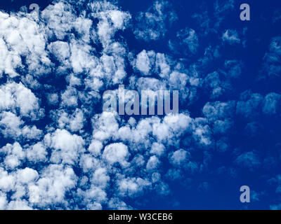 Cirrocumulus clouds are small rounded puffs that usually appear in long rows high in the sky. Cirrocumulus are usually white Stock Photo