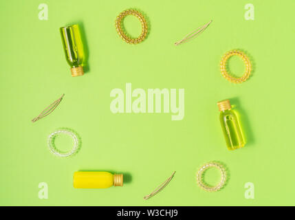 Flat lay of hair care products and styling items on green background. Women beauty and beauty salon cosmetics concept. Copy space. Stock Photo