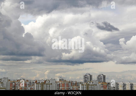 Storm sky over the city buildings covered with dark cumulus clouds before the rain. Urban landscape in overcast day, beautiful dramatic background Stock Photo