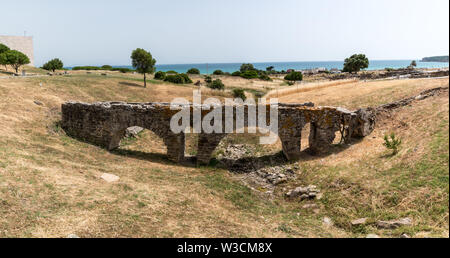 The Paloma aqueduct with the Atlantic ocean in the background located at the ancient Roman city Baelo Claudia in Bolonia, Spain near Gibraltar. Stock Photo