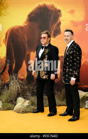 London, UK. 14th July 2019. Sir Elton John and husband David Furnish poses on the yellow carpet at the European premiere of Disneys 'The Lion King' on Sunday 14 July 2019 at ODEON LUXE Leicester Square, London. Elton John, David Furnish. Picture by Julie Edwards. Credit: Julie Edwards/Alamy Live News Stock Photo