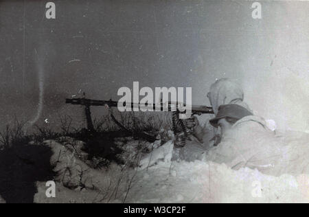 German Soldiers in White Winter Camouflage  fire a Light Machine Gun on the Russian Front 1942 Stock Photo