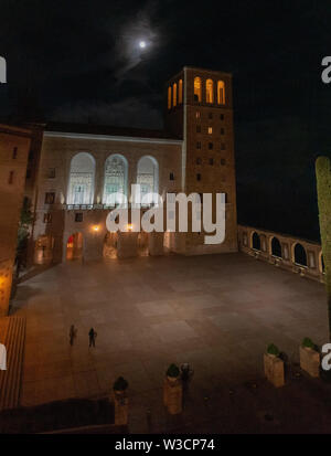 A panoramic view of Santa Maria de Montserrat Abbey near Barcelona, Spain at night with the moon overhead Stock Photo