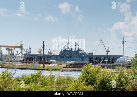 The ship yard of Ingalls Shipbuilding with several military Navy war ships Stock Photo