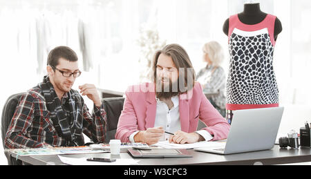 two fashion designers discussing designs of the new models. Stock Photo