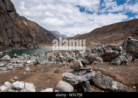 The smallest of Gokyo lakes in Nepal Himalayas and surrounding scenery, including traditional towers of stones Stock Photo