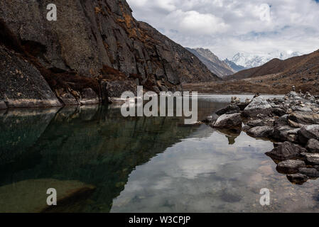 Clear water and reflections in the smallest of Gokyo lakes in Nepal Himalayas Stock Photo