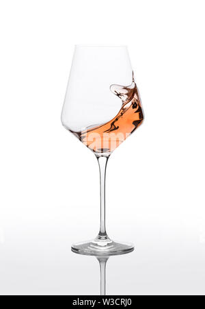 Glass of amber wine with splashes on white table. Stock Photo