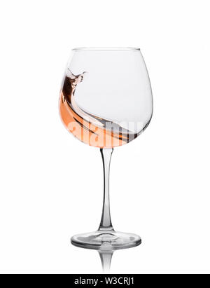 Glass of amber wine with splashes isolated on white. Stock Photo