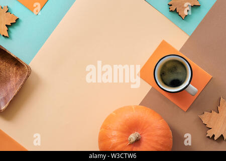 Autumn background with cup of coffee and wooden maple leaves on geometric paper background with copy-space Stock Photo