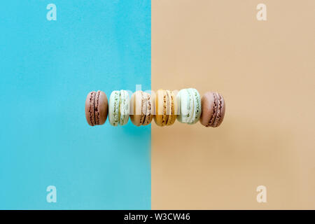 Row of weet and tasty macarons, flat lay on split paper background Stock Photo