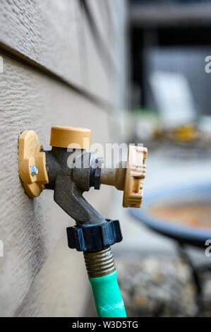 Handle-Operated Freezeless Residential Wall Hydrant mounted on exterior of house Stock Photo