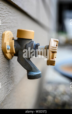 Handle-Operated Freezeless Residential Wall Hydrant mounted on exterior of house Stock Photo