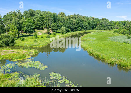 beautiful park landscape in summer with green trees, lawns and river Stock Photo